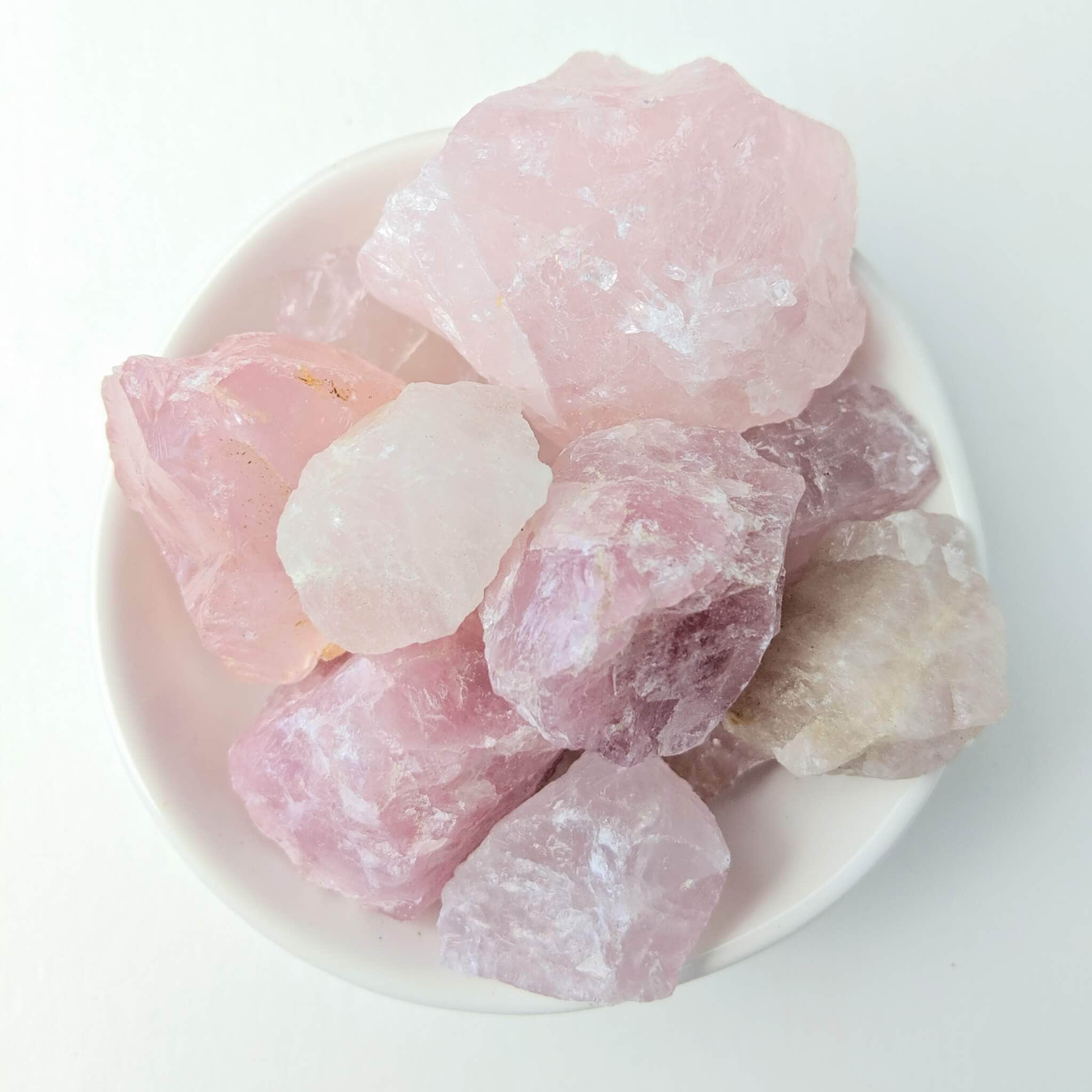 Rose Quartz Crystal Raw Pieces in a White Bowl Top View
